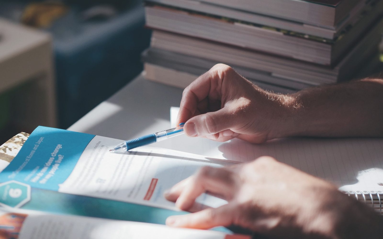 Hands annotating a printed report with a pen.